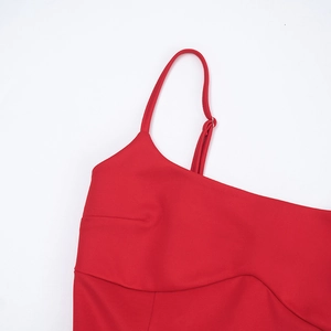 Detail of red dress showing adjustable spaghetti strap and fine stitching on fabric