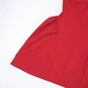 Detail of red sleeveless dress showing gathered ruffles and high-quality fabric texture