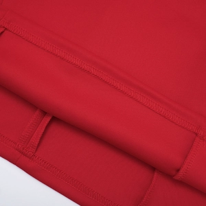 Detailed close-up of the hemline stitching and fabric texture on a red sleeveless dress