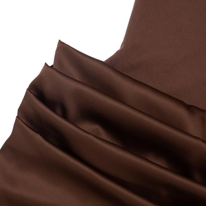 Detailed close-up of dark brown satin and matte fabric stitching with elegant draped folds
