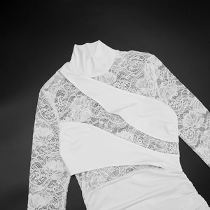 Detailed view of elegant white lace dress with mock neck and cross-wrap bodice design
