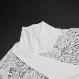 Detail of elegant white lace dress with high neck and intricate floral hollow embroidery