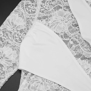Detailed close-up of white floral lace fabric and smooth stitching on a bodycon dress