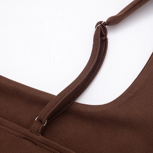 Detail view of brown square neck dress featuring adjustable metallic straps and fine stitching