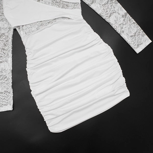 Flat lay of white bodycon dress with lace sleeves and ruched texture on black background