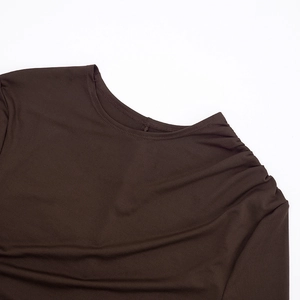Detail of dark brown long sleeve dress featuring crew neck and elegant shoulder ruching