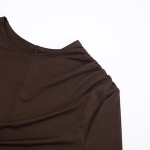 Detailed close-up of dark brown ruched shoulder and asymmetric neckline design