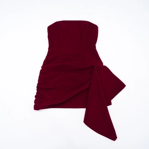 Détail de la robe bustier en velours bordeaux avec fronces et drapé asymétrique élégant