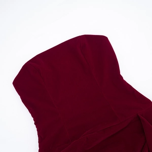 Gros plan sur la texture velours bordeaux élégante et les coutures de la robe bustier