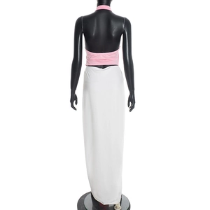 Detail view of pink halter backless top and white long skirt on a black mannequin