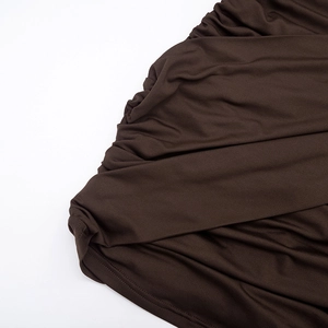 Detailed view of chocolate brown ruched fabric with smooth elastic texture on the dress