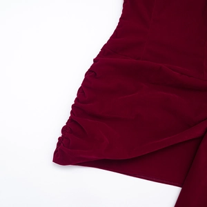 Détail de robe en velours bordeaux avec fronces latérales élégantes et texture douce