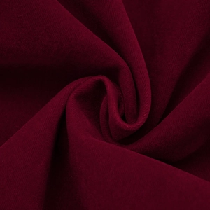 Gros plan sur un tissu en velours rouge foncé avec une texture lisse et soyeuse