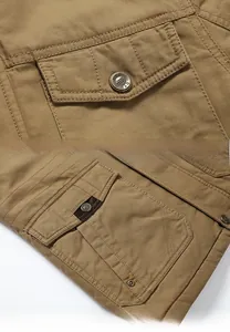 Dettagli dei bottoni in resina e tasche oblique a contrasto sulla giacca di cotone kaki