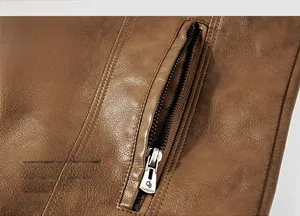 Close-up of metal zipper pocket and textured brown grain leather on a biker jacket