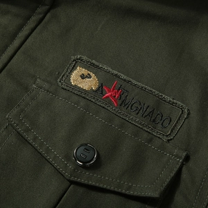 Detailed view of the dark green cotton cargo jacket with embroidered patch and stitching