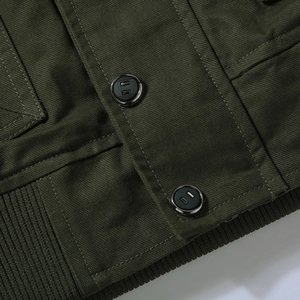 Detail of army green cargo jacket featuring metal buttons and ribbed hem texture