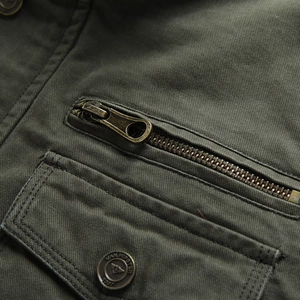 Detail der armee-grünen Baumwolljacke mit Metall-Reißverschluss und Markenknöpfen