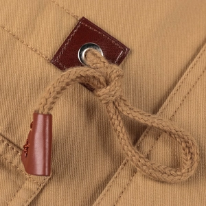 Dettaglio della giacca in twill kaki con fermacorda in pelle e occhiello in metallo