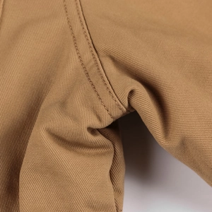 Dettaglio ravvicinato delle doppie cuciture resistenti sul tessuto in twill kaki