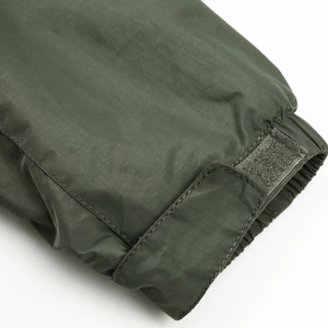 Dettaglio macro del polsino della giacca verde militare con chiusura in velcro regolabile