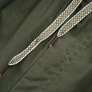 Detail of olive cotton cargo pants showing woven drawstring and double stitching
