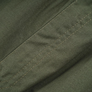 Detail of heavy-duty cotton cargo pants showing durable double-stitched seams and fabric texture