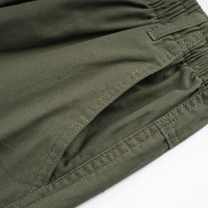 Detail showing elastic waist with drawstring and side pocket on army green cargo pants