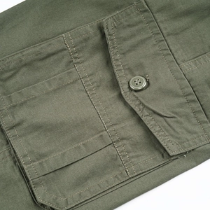Detail view of military green cotton cargo pants featuring a buttoned flap pocket