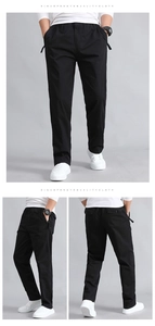 Detail view of men's black straight-leg trousers with elastic drawstring waist and pockets