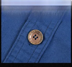 Detail of blue cotton twill shirt showing precise double stitching and vintage metal button