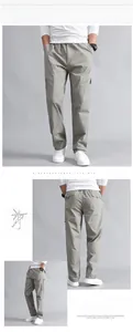Detail view of light grey cargo pants with side pockets and elastic waist design