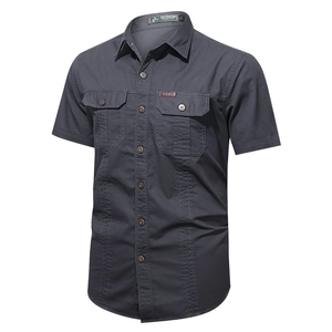 Detail of dark grey short sleeve outdoor shirt with buttoned chest pockets and leather tag