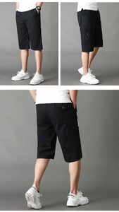 Detalle de pantalones cortos cargo negros con cintura elástica de cordón y bolsillos con cremallera