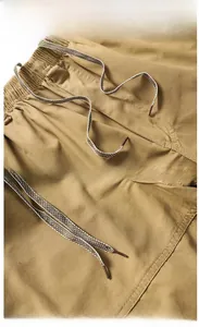 Detalle de los pantalones cortos casuales caqui con cintura elástica y cordón a rayas