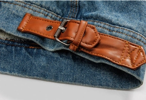 Dettaglio della giacca di jeans con cinturino in pelle marrone e fodera in caldo pile bianco