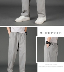 Detail view of light grey cargo pants showing elastic waist and multi-pocket design