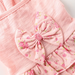 Detailed view of pink floral bow and ruffled hem on soft cotton pet summer dress