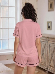 Back view of pink short-sleeve pajama set for women with black contrast piping detail