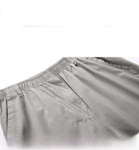 Detail of grey men cargo trousers showing elastic waist, belt loops and twill fabric texture