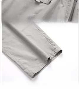 Detailed view of reinforced stitching on gray cargo pants pockets and straight hem design