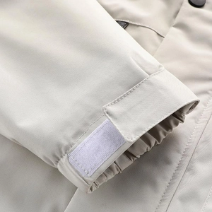 Dettaglio del polsino regolabile in velcro e cuciture fini di una giacca termica beige