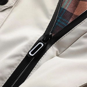 Dettaglio della cerniera a contrasto e fodera a quadri di un parka beige caldo da esterno