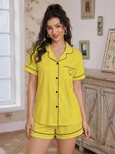 Detail of yellow loungewear set featuring contrast piping and a heart embroidery on pocket