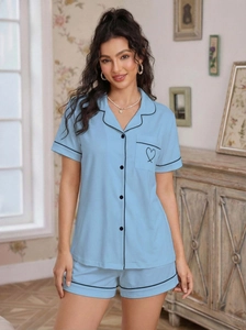 Detail of light blue short sleeve pajama set with black piping and heart pocket design