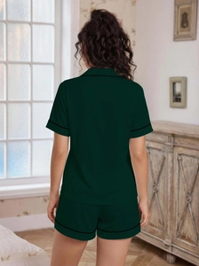 Detail showing the back view of dark green short-sleeved pajamas with black piping trim