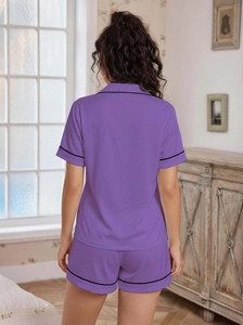 Detail view of purple short-sleeve pajama set featuring contrast black piping on the back