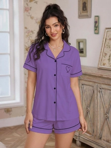 Detail of lavender pajama set featuring black contrast piping and heart embroidery