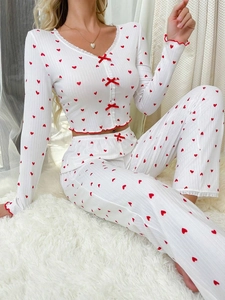 Detail of ribbed pajama fabric with red hearts, lace trim, and decorative bows