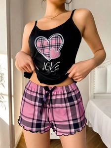 Détail du haut à bretelles avec imprimé cœur et short à carreaux rose avec un nœud